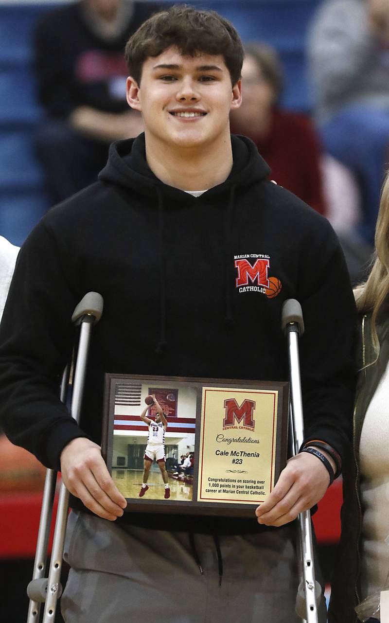 Marian Central’s Cale McThenia is honored for schooling over 1,000 career points during a nononference boys basketball game against Marengo on Tuesday, Feb.13, 2024, at Marian Central High School.