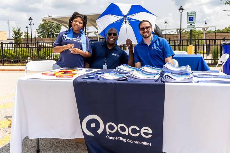 Amber Aikerson, Charles Aikerson (Pace Marketing Promotions Coordinator), and Ed Gallagher (Pace Costumer Relations Representative) greet Activate Joliet attendees on Aug. 3, 2024.