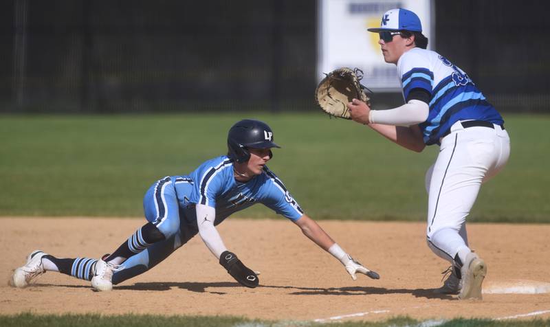 Lake Park's Michael Christiansen, left, slides safely back to first base as St. Charles North's Colin Ryder waits for the throw during Friday’s baseball game in St. Charles.