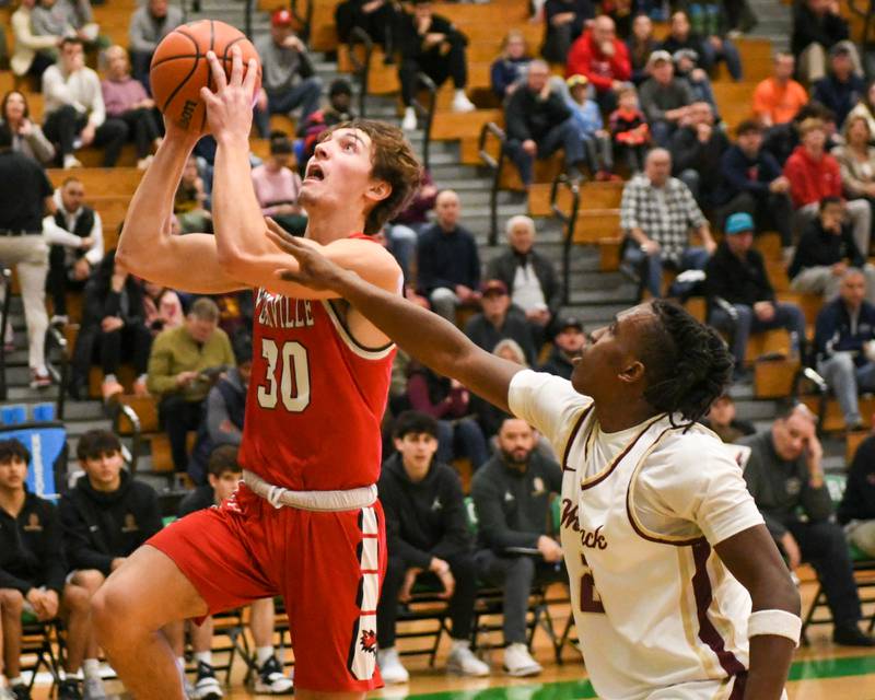 Yorkville's Bryce Salek (30) makes a basket while being defended by St. Ignatius's Reggie Ray (25) during the second quarter on Tuesday Dec. 26, 2023, during the Jack Tosh tournament held at York High School in Elmhurst.