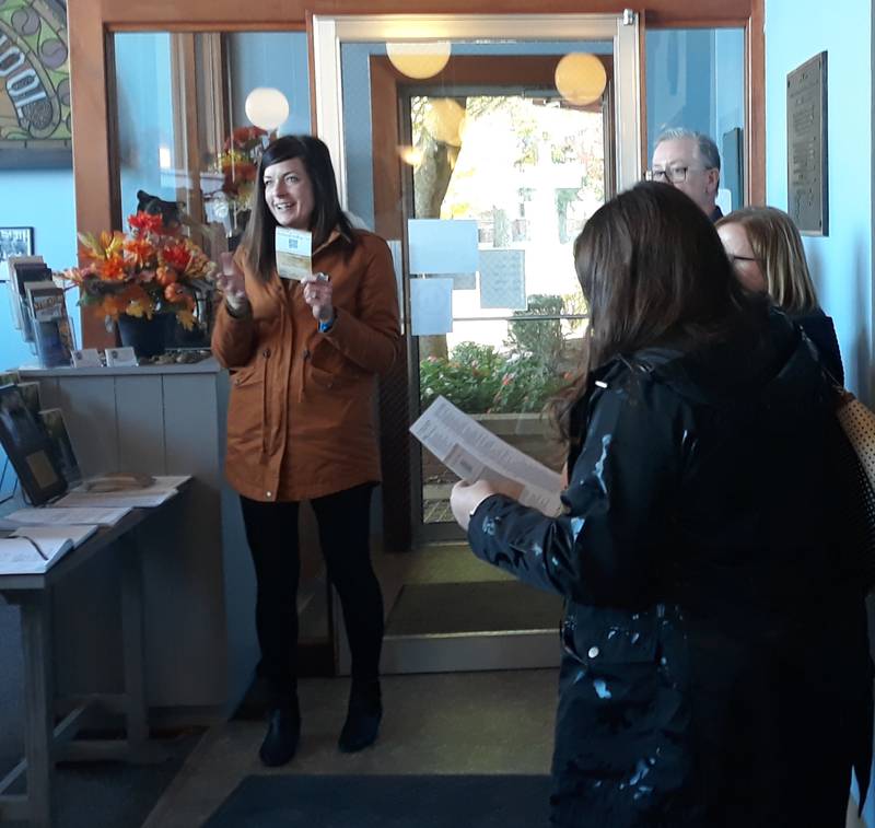 Streator Chamber of Commerce Executive Director Courtney Levy holds up a card containing the QR code that will cue the audio historical tour on a visitor's cellphone during its unveiling Friday, Oct. 14, 2022, at the Streatorland Historical Museum.