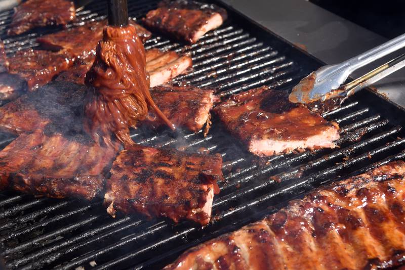 Joe Lewnard/jlewnard@dailyherald.com
Ribs are mopped with sauce at the Salt Creek Barbecue booth during the opening day of Ribfest at the DuPage County Fairgrounds in Wheaton Friday.