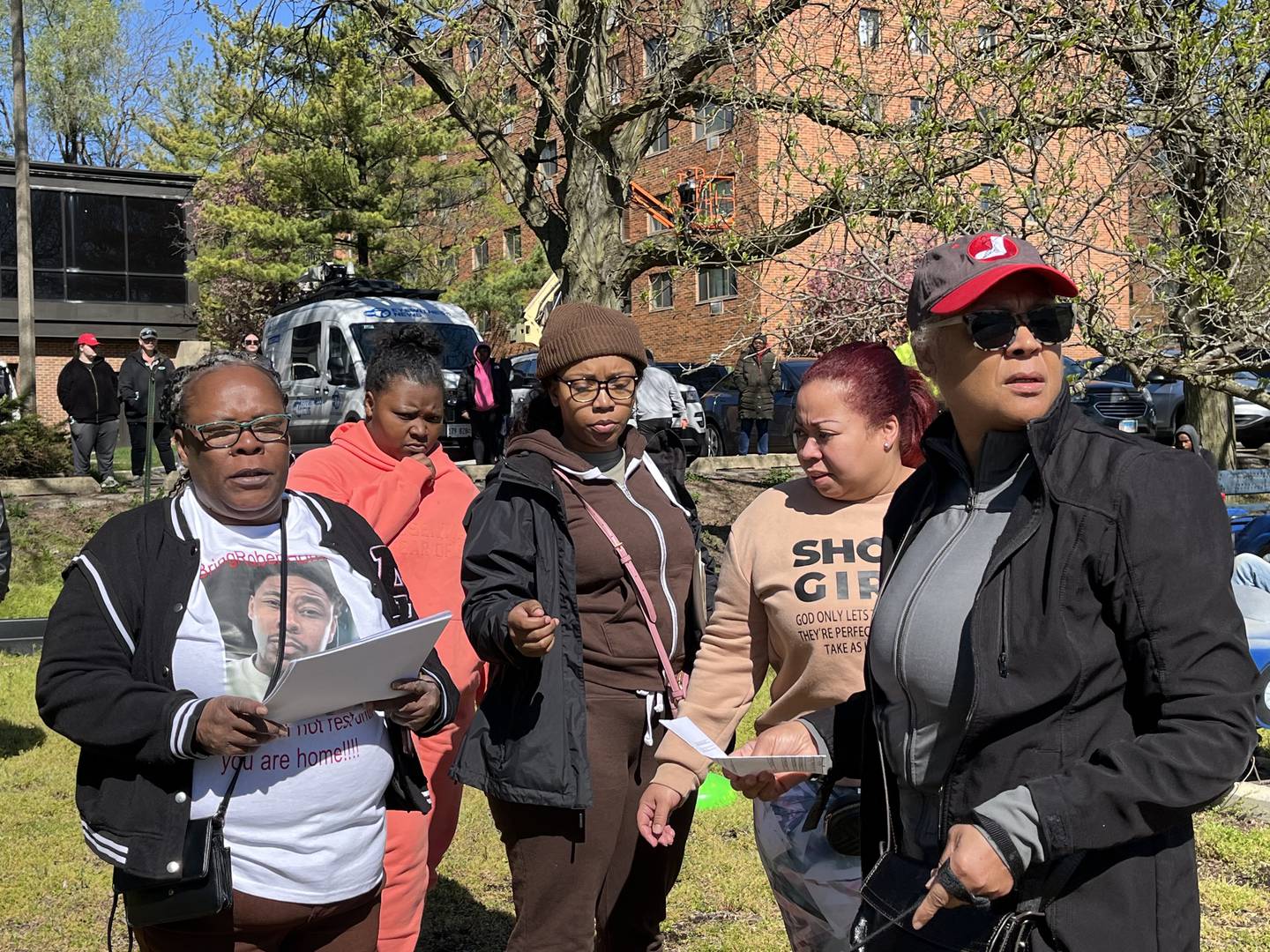 Jewell Robinson (left) passes out fliers to family, friends and others on Friday, April 19, in Joliet, for the search of her missing son, Robert Long, 37.