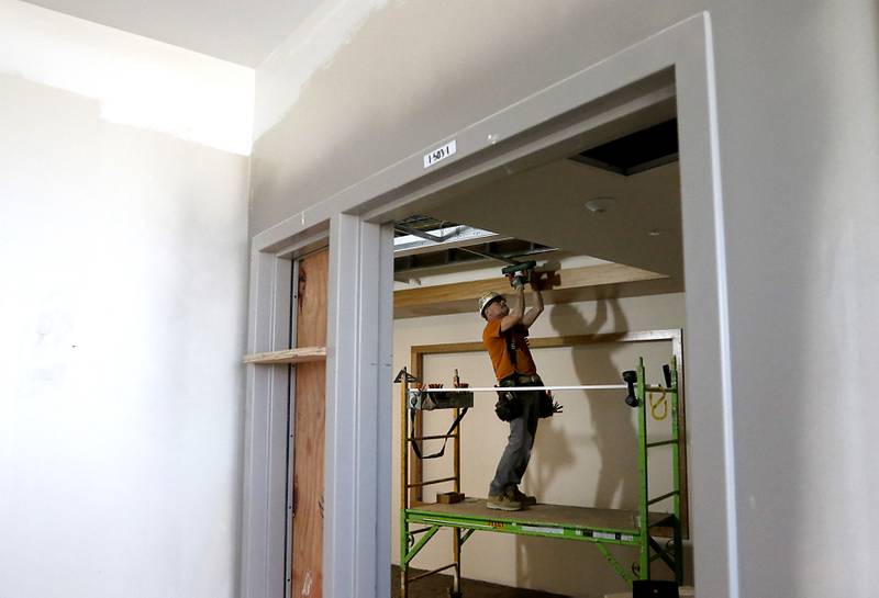 A construction worker installs a ceiling on Friday, April 21, 2023, as construction continues on the new Mercyhealth hospital in Crystal Lake. The hospital is ramping up hiring as it gets set to open in this summer.