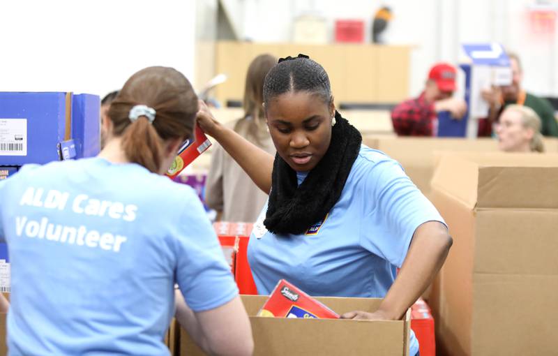 ALDI employee Jazmine Butler packs boxes at the Northern Illinois Food Bank in Geneva during an effort to pack more than 6,000 disaster relief packages for Feeding America and the Northern Illinois Food Bank on Tuesday, May 7, 2024.