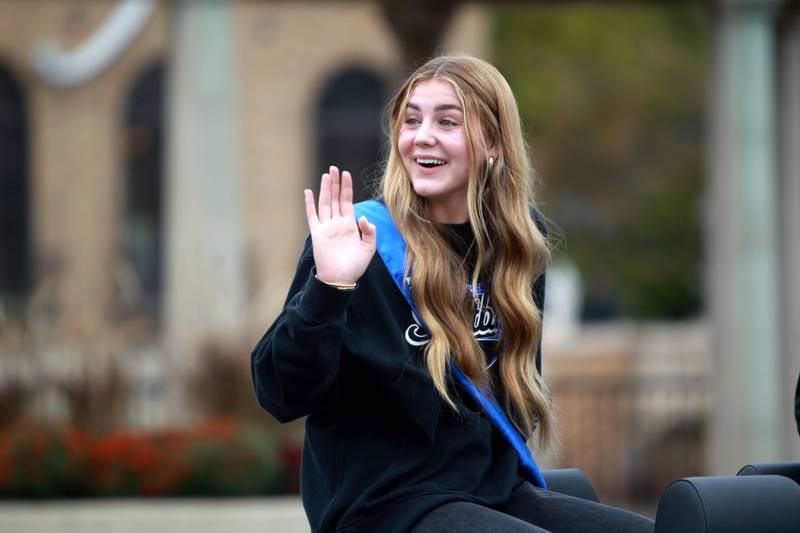 St. Charles North softball player Haley Nelson waves from the top of a convertible during the school’s annual homecoming parade on Main Street through downtown St. Charles on Thursday, Oct. 19, 2023.