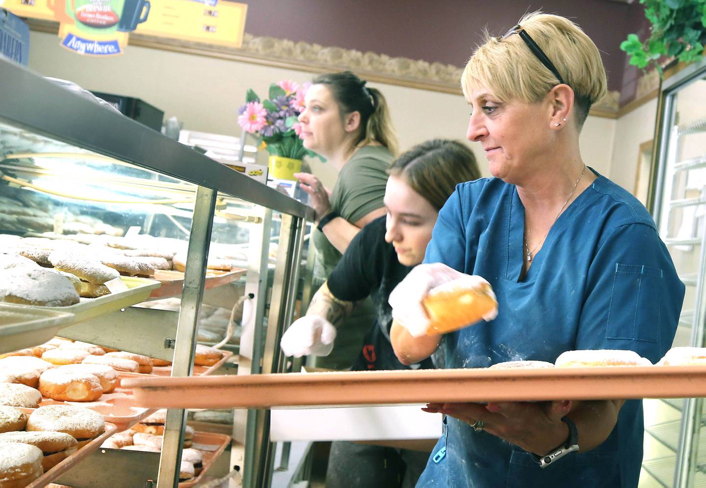 Dawn Ekstrom, (right) manager at Elleson's Bakery, along with employees Zoe Durst and Jill Malloy, fill paczki orders Tuesday, Feb. 21, 2023, at the bakery in Sycamore. Elleson’s is always full of customers on Fat Tuesday, also known as Paczki Day, due to the tradition of enjoying the fried Polish dessert.