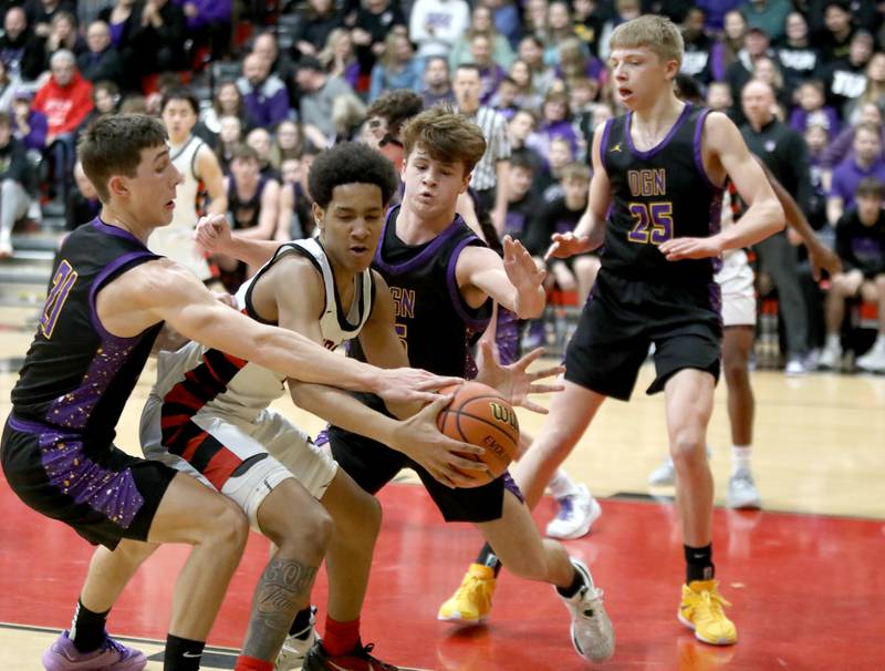 Bolingbrook’s Davion Thompson (center) is surrounded by Downers Grove North’s Jack Stanton (left) and Owen Thulin (right) during the Class 4A East Aurora Boys Basketball Sectional final on Friday, March 1, 2024.