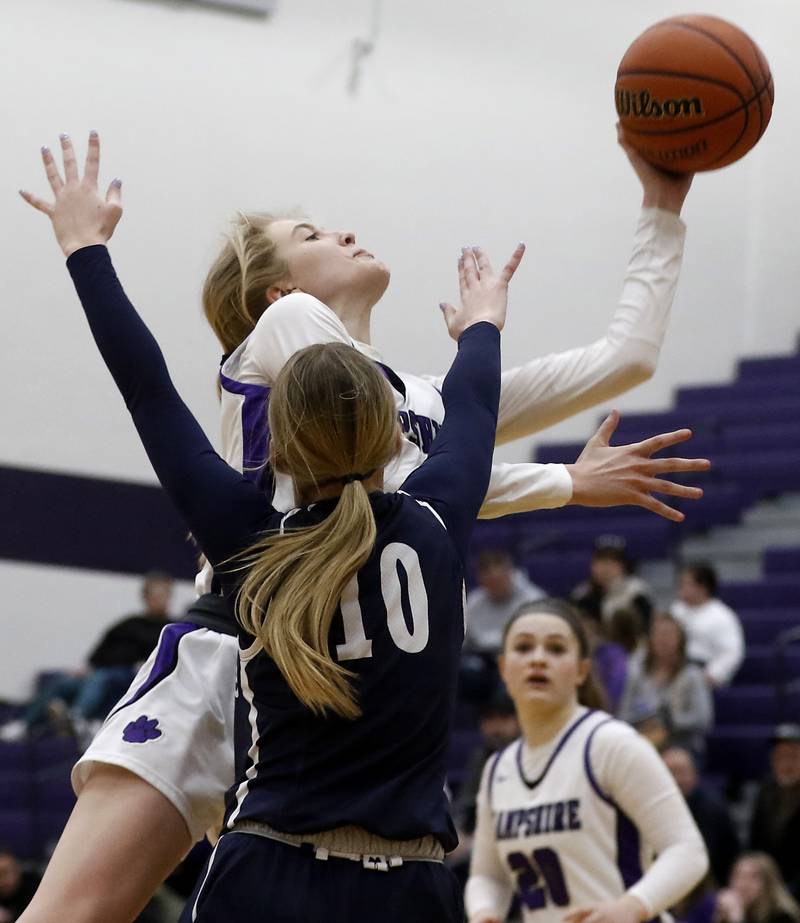 Hampshire's Avery Cartee shoots the ball while she is defended by Cary-Grove's Alivia Nielsen during a Fox Valley Conference girls basketball game Friday, Jan. 26, 2024, at Hampshire High School.