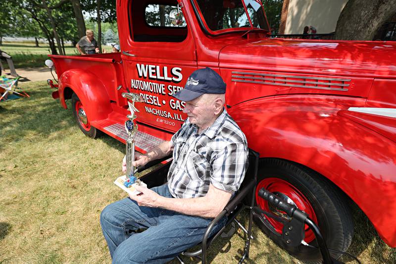 Sam Wells sits by his old truck with his new “Best Senior Car” trophy Friday, June 23, 2023 at Franklin Grove Assisted Living.