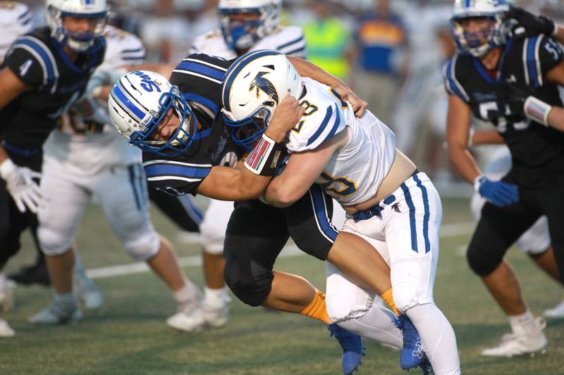 St. Charles North’s Wyatt Brandt (left) takes down Wheaton North’s Max Serbick during a game Friday, Sept. 13, 2024 at St. Charles North.