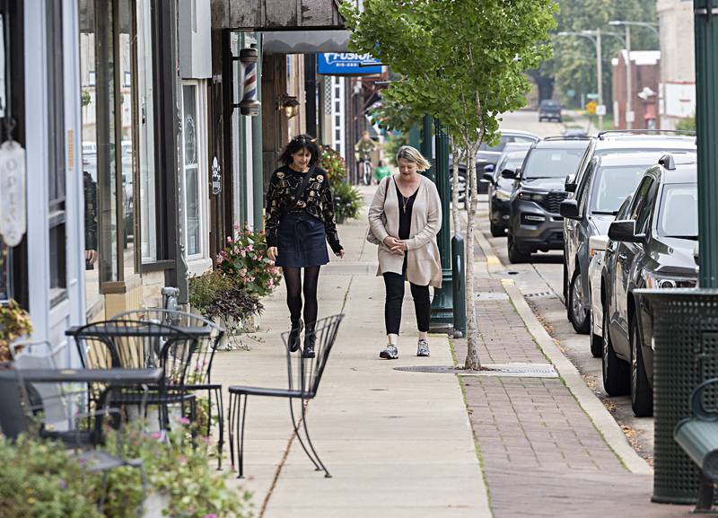 Nikki Lovette (left) and Letha Catalina walk from business to business Thursday, Oct. 12, 2023 during the Witches Night Out.