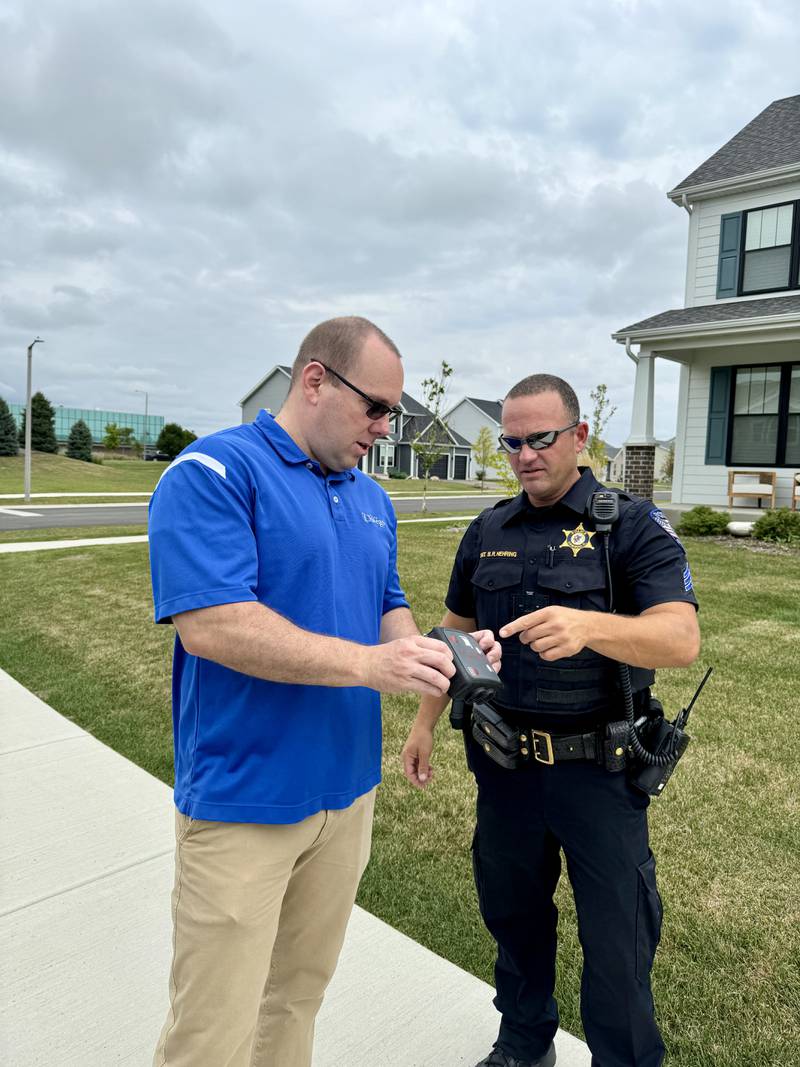 Oswego Police Sgt. Brian Nehring, right, explains how to use the speed radar unit to Village President Ryan Kauffman, left.