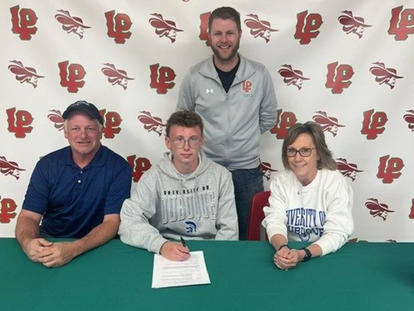 La Salle-Peru senior Andrew Bollis (seated, center) committed to play tennis at the University of Dubuque. He was joined by his parents (seated), Don and Jill, and L-P coach Aaron Guenther.