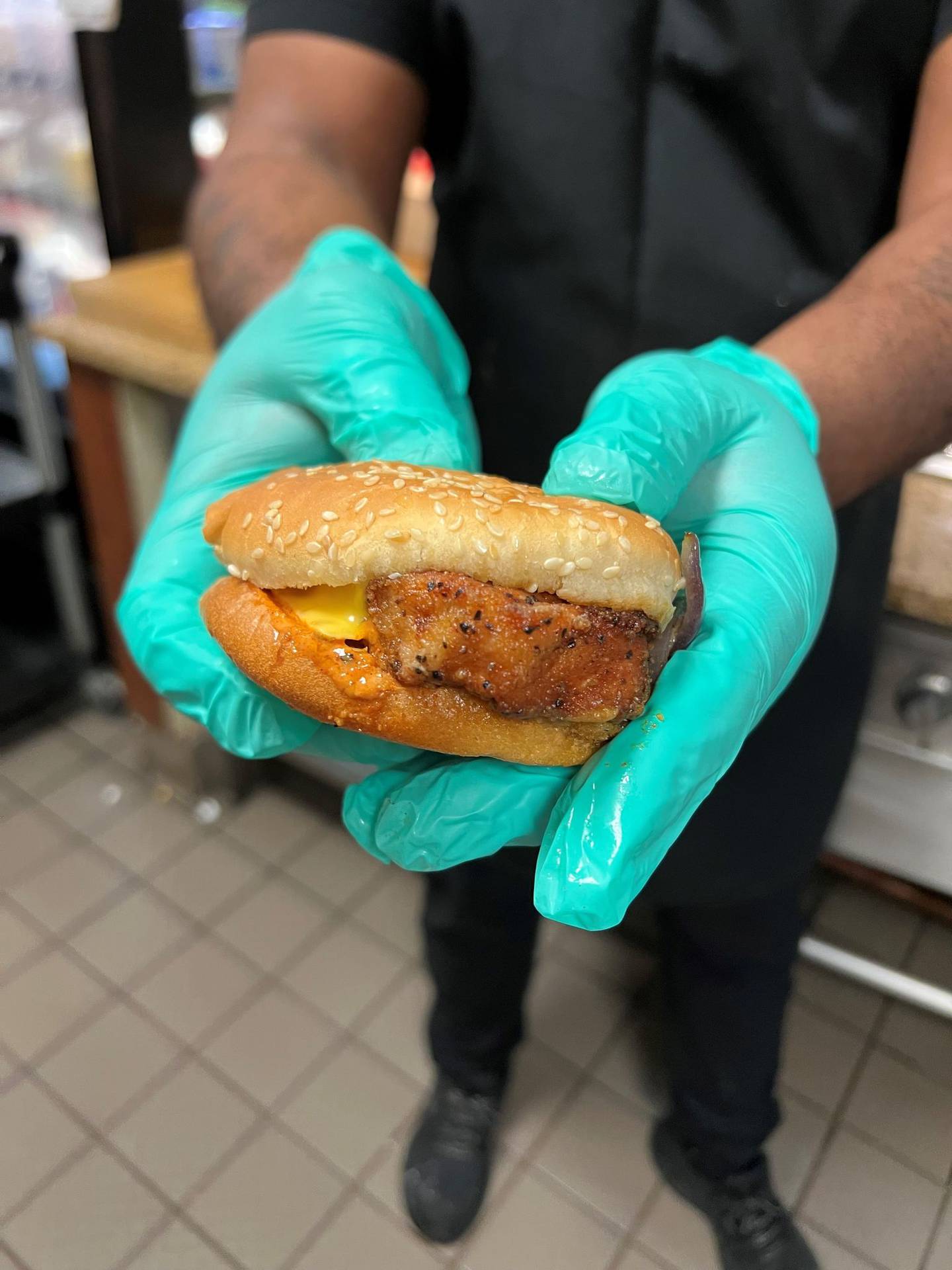 George Funches of Crest Hill shows off the pork tenderloin sandwich he developed for the cafeteria at Silver Cross Hospital in New Lenox. The sandwich consists of a deep-fried pork tenderloin, spicy mayonnaise, grilled onions, American cheese and warmed-up sesame seed bun.