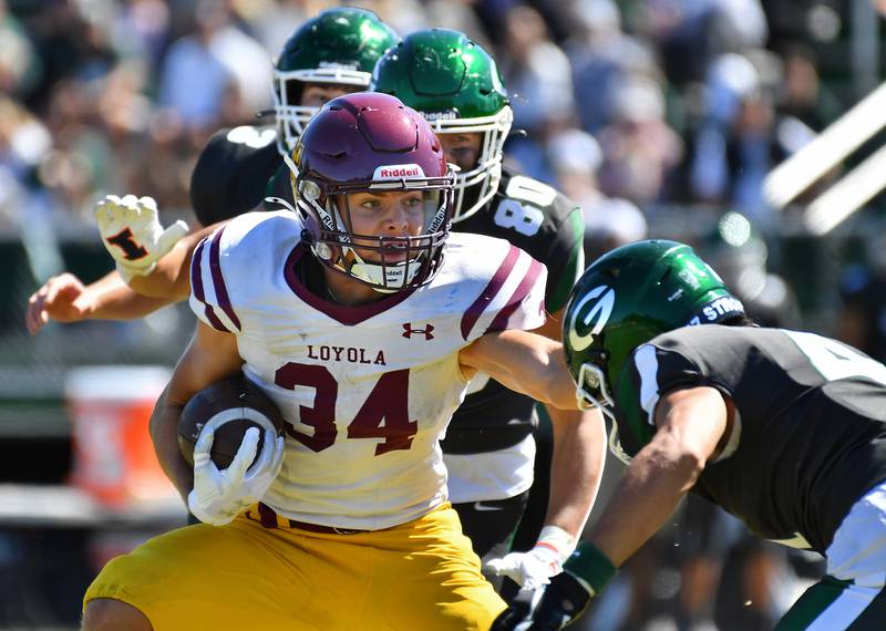 Loyola's Drew MacPherson (34) tries to sidestep Glenbard West's Mason Ellens (right) during a game on September 7, 2024 at Glenbard West High School in Glen Ellyn.