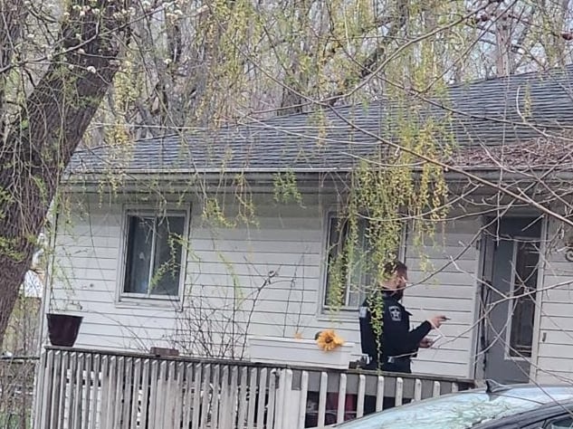 An officer stands in front of a home near Johnsburg in a neighborhood where McHenry County Sheriff's deputies shot and killed a dog after a dogfight that authorities said injured several people. At least one deputy was also injured trying to corral the dogs after two got loose.