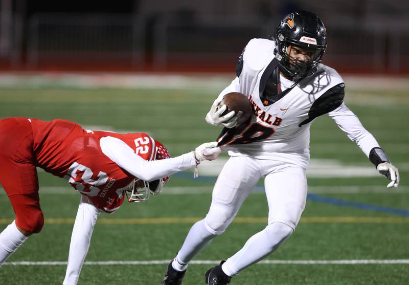 DeKalb’s Derrion Straughter tries to break away from Naperville Central's Nathan Monken during their game Friday, Oct. 6, 2023, at Naperville Central High School.