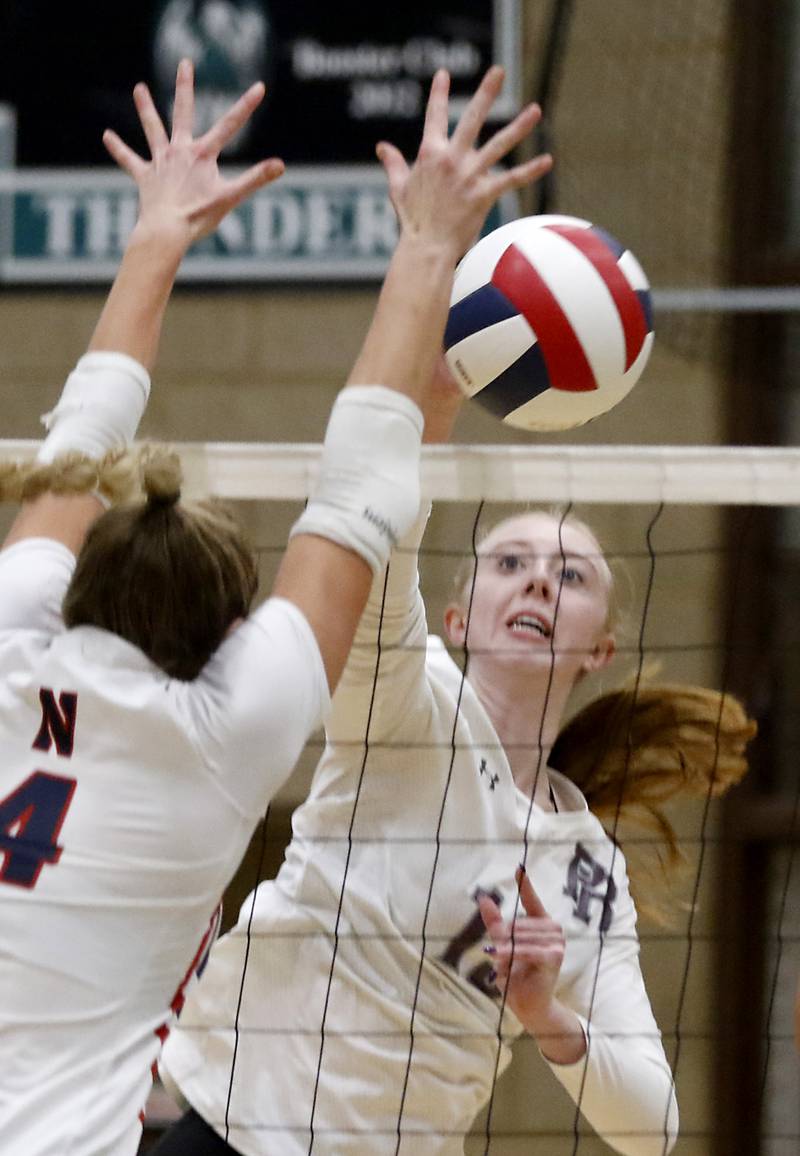 Prairie Ridge's Ashley Stiefer spikes the ball past the block of Belvidere North's Bree Messenger during the Class 3A Woodstock North Sectional finals volleyball match on Wednesday, Nov. 1, 2023, at Woodstock North High School.