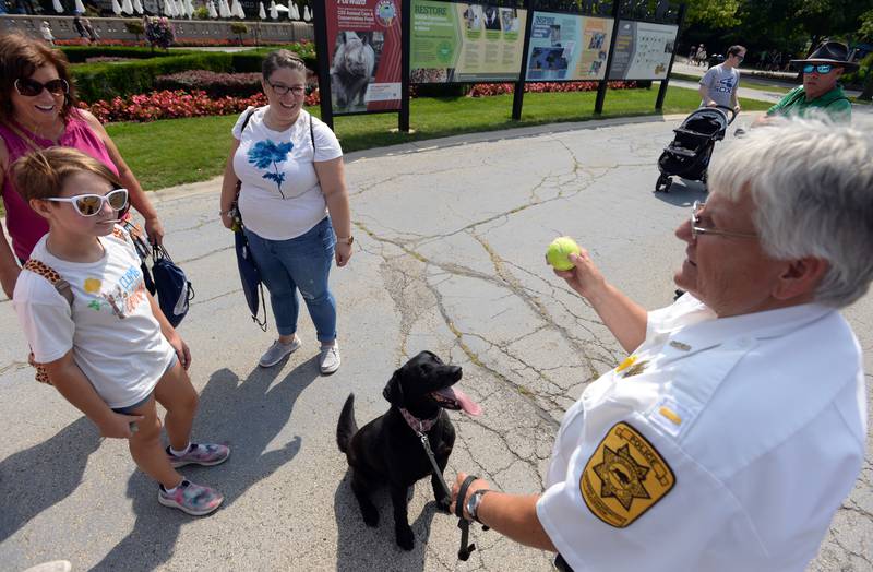 (left-right) Brooklyn Adams, Beth Seifert and Jen Adams of Indiana enjoy time with Brookfield Zoo's Lieutenant Barb Clash and her dog Kirby during the First Responders event held Sunday Aug 28, 2022.