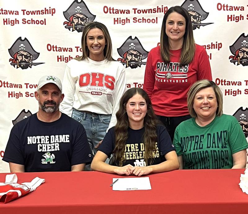 Ottawa’s Maggy Buscher has signed to continue her education at the University of Notre Dame in Notre Dame, Ind., and her cheer career with the Fighting Irish. Buscher, seated at center, is pictured here at her signing ceremony alongside her parents with her Ottawa High School cheer coaches standing behind.