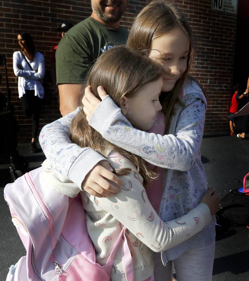 Mia Sobonkiewicz, 9, hugs her sister, Olivia, 7, before they separate to go to their classroom lines for the first day of school on Wednesday, Aug. 21, 2024, at Coventry Elementary School in Crystal Lake.