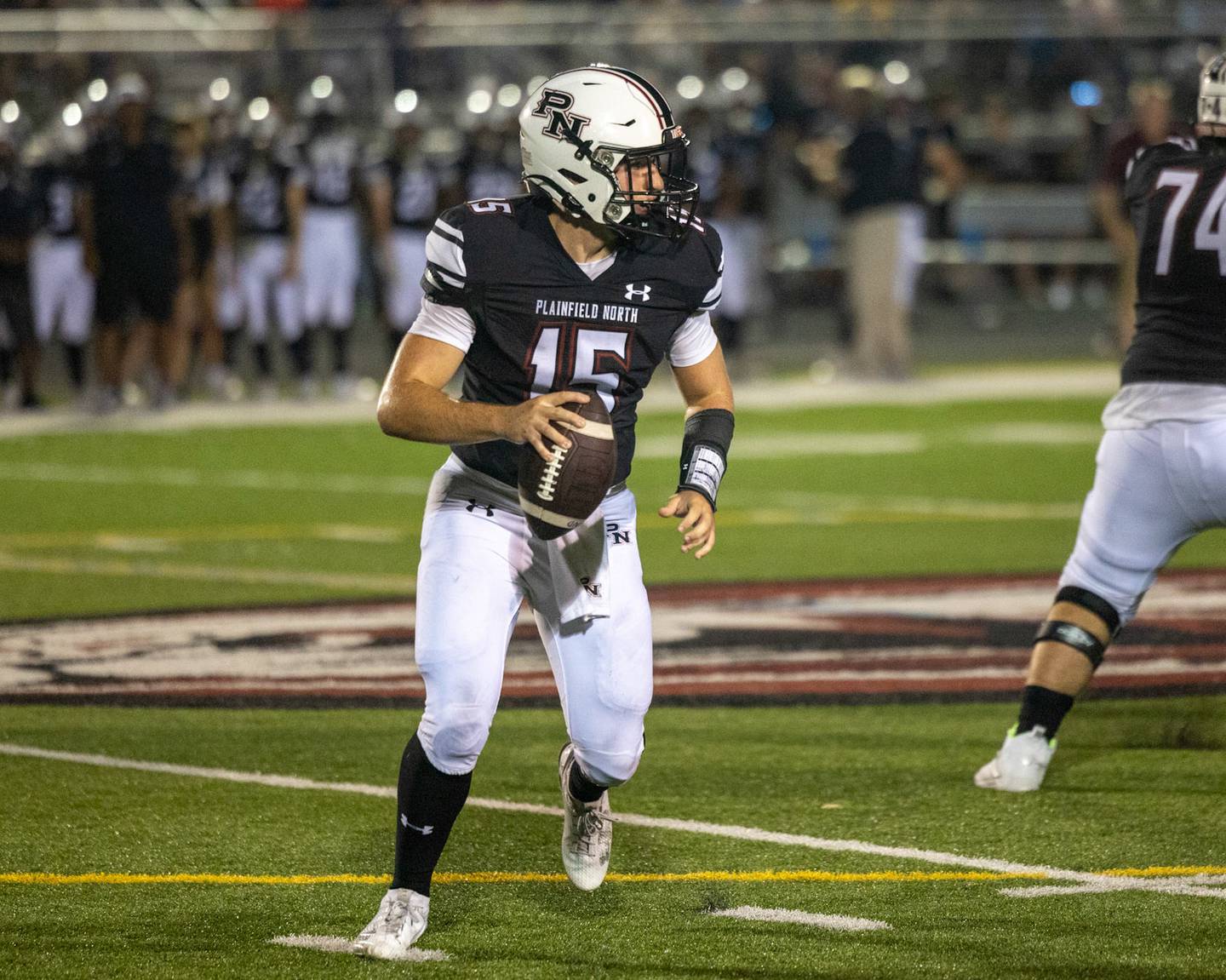 Plainfield North’s Nicholas Darwish rolls out of the pocket against Lockport on Friday, Aug. 25, 2023 in Plainfield.