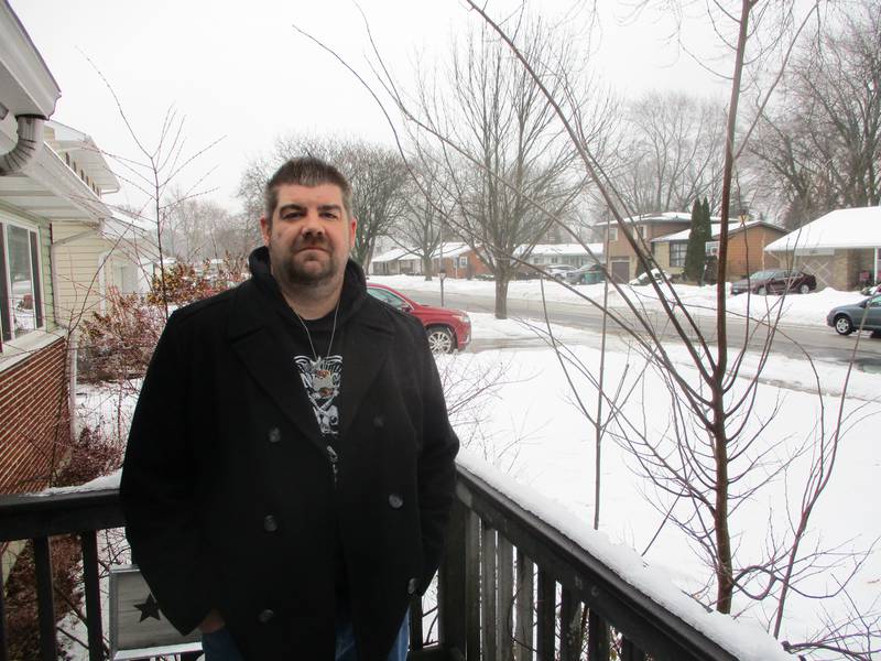 Dan Burns stands on the porch of his Joliet home on Taylor Street, the next street over from the where the West Acres Road killings occurred. Jan. 23, 2024.