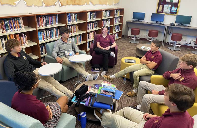 Senior Dominic Catalano (in gray) and junior Nicholas Sheeran (in black) lead their small group in asking ice-breaker questions.