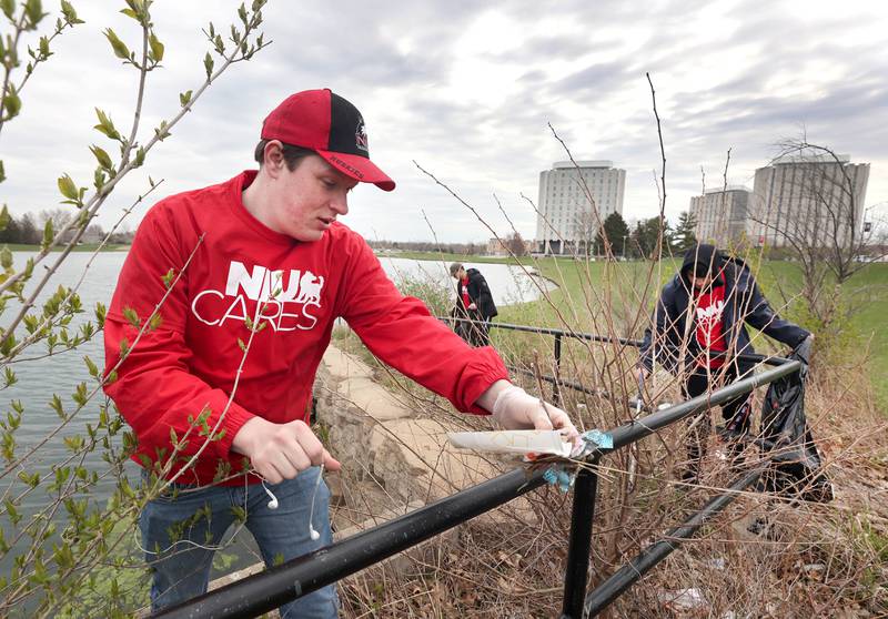 Matthew Outzen, a Northern Illinois University senior from Fulton and a member of NIU Cares, picks up garbage Friday, April 29, 2022, on campus around the West Lagoon. NIU Cares, with the help of the Trash Squirrels, was taking part in a community cleanup event, going to several locations in DeKalb to pick up litter.