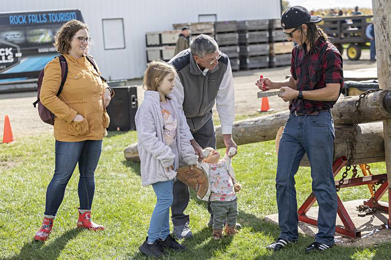 Mom Allison, Evelyn, 9, Lyra, 1, and grandpa Bill Chaplin meet lumberjack Brett Wells at the end of the first show Saturday, Oct. 7, 2023 in Rock Falls.