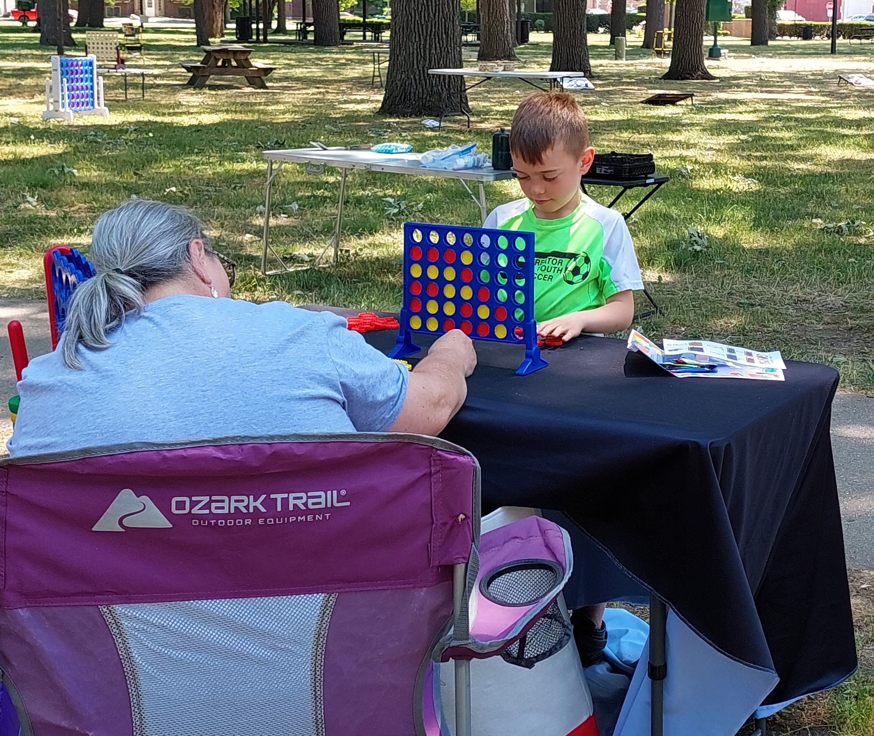 Killian Caulkins plays a game of Connect Four on Saturday, June 10, 2023, at City Park as part of Live Well Streator's Family Health and Fitness Day.