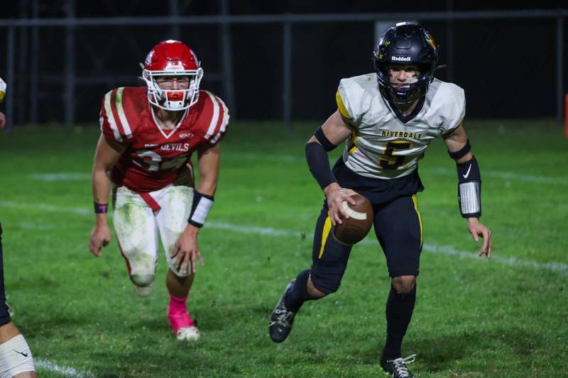 Kolton Kruse of Riverdale runs ball whilst Aiden Redcliff of Hall trails behind him on Friday, October 18, 2024 at Richard Nesti Stadium in Spring Valley.