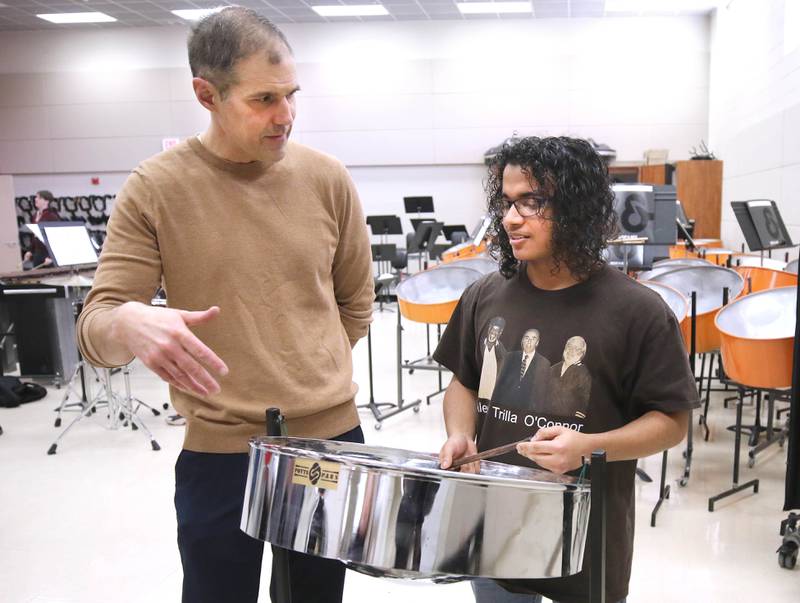 Jaden Teague-Núñez, 16, a sophomore at DeKalb High School, with the steelpan as Steve Lundin, the schools director of bands, looks on Monday, March 18, 2024, in the band room at the school. Teague-Núñez won first place in the Chicago Symphony Orchestra’s Young Artists Competition and will appear as a soloist in a CSO youth concert during the 2024-25 season.