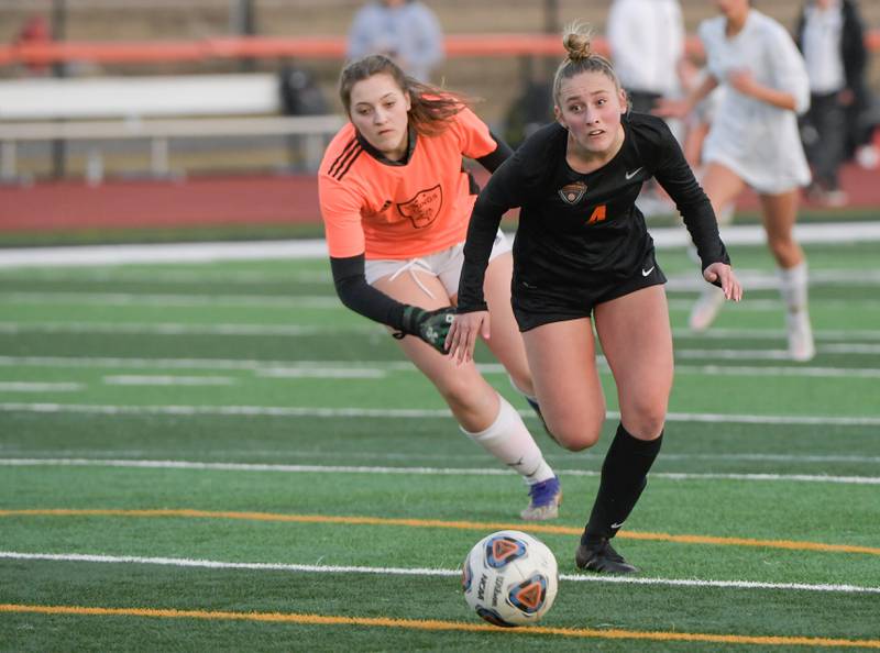 St. Charles East's Grace Williams (4) moves the ball around Fremd goalkeeper Sam Gary (0) to score during the 1st half during a game on Tuesday, March 15, 2022.