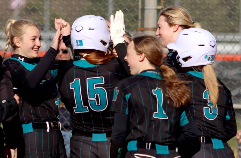 Woodstock North’s Mackenzie Schnulle is greeted at the plate on a home run in varsity softball at Crystal Lake Central Friday.