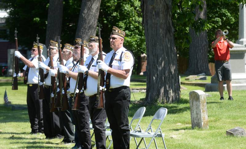 Oregon High School band member Isaac Ebert (far right) plays taps with his bandmate Gavin McCarty (not pictured) as seven veterans stand at attention during the Memorial Day service at Riverside Cemetery in Oregon on Monday, May 27, 2024.