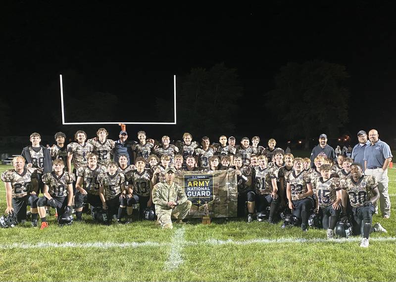 The Flanagan-Cornell/Woodland football team poses with Illinois Army National Guard recruiter Sgt. Kody Montoya, front row center, while wearing National Guard-themed camouflage uniforms after FCW's 38-8 victory Friday, Sept. 6, 2024, in Flanagan.