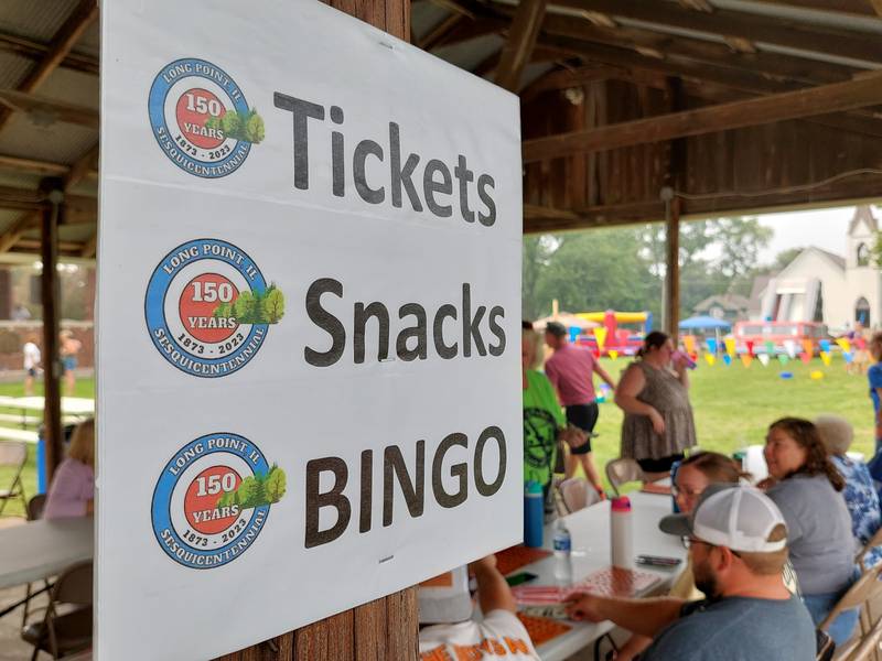 A handful of people play bingo under a shelter Sunday, July 16, 2023, during Long Point's Sesquicentennial celebration.