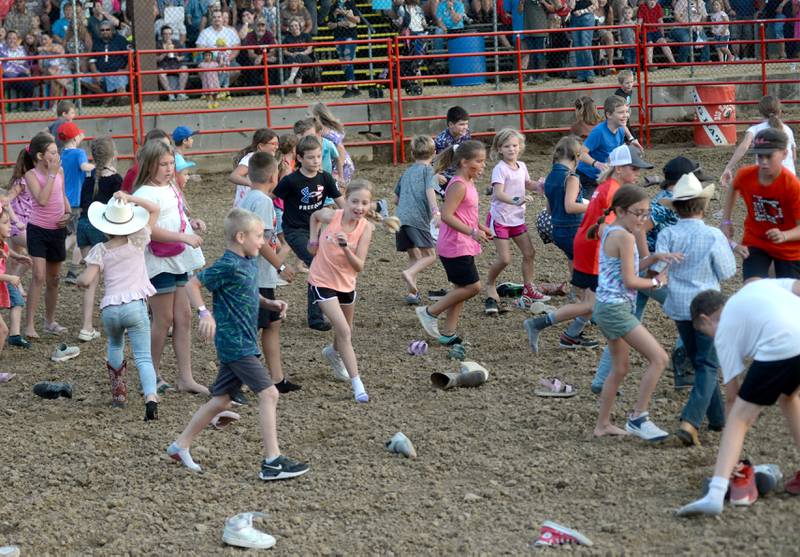 Kids rush to find their shoes during entertainment at the Big Hat Rodeo during the Ogle County Fair on Friday, Aug. 4, 2023.