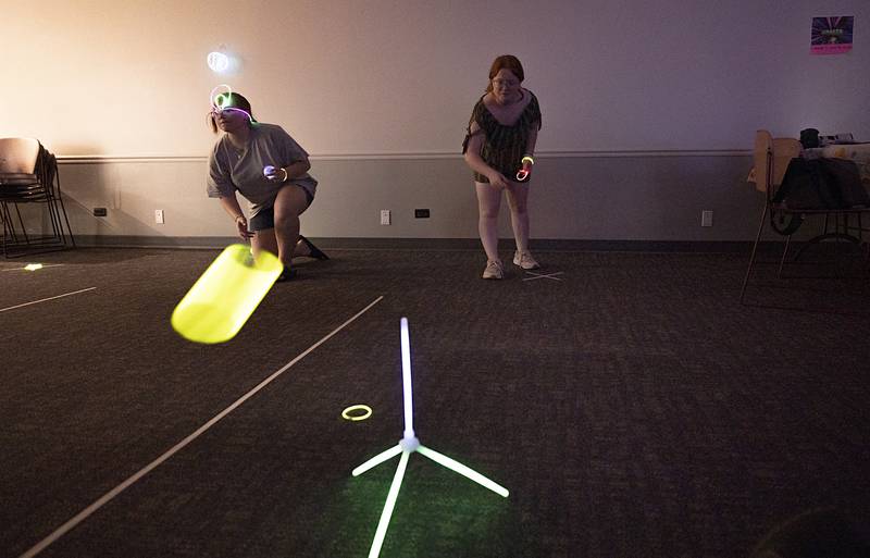 Lillyanna Tranbarger (right) tosses a glow ring at a target Tuesday, July 16, 2024, at the Dixon Public Library.