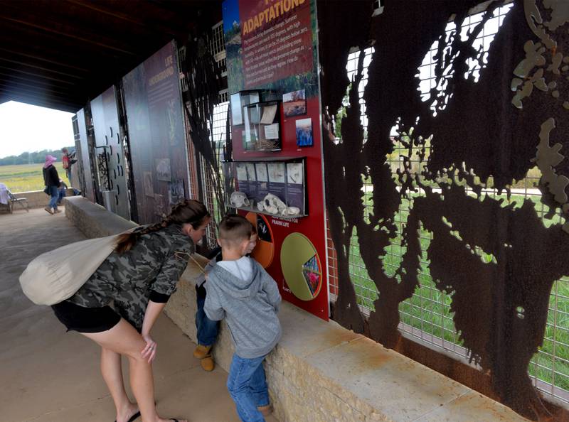 Brittany Chisamore of Rochelle, checks an interactive display with two of her sons, Easton, 5, and Wyatt 4, at the Visitor Center during the Nachusa Grassland's Autumn on the Prairie on Saturday, Sept. 16, 2023.