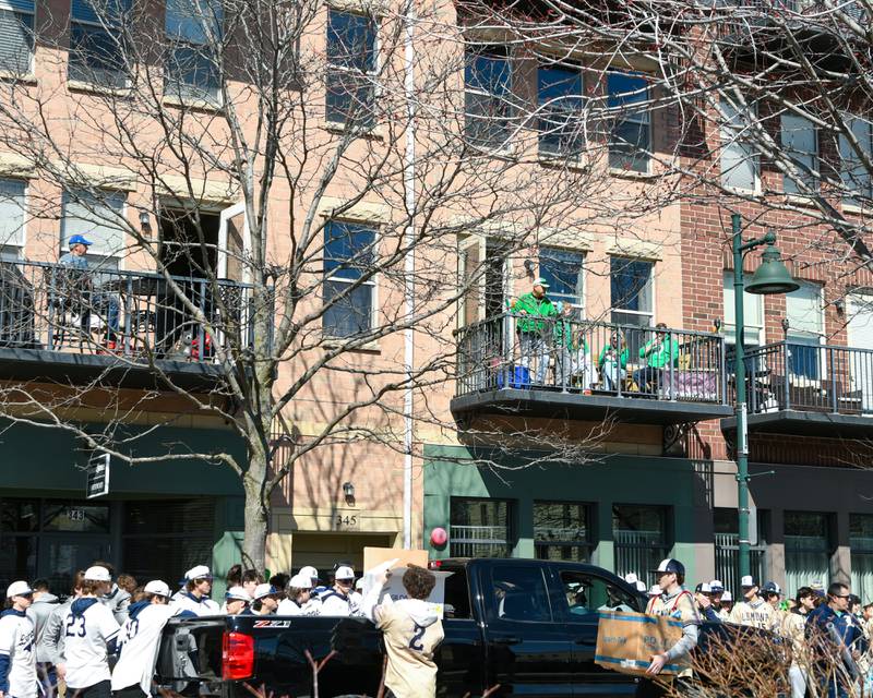 Lemont residents hang out on their decks as Lemont’s baseball team and other St. Patrick’s parade entries line up before the start of the Parade on Saturday March 9, 2024.