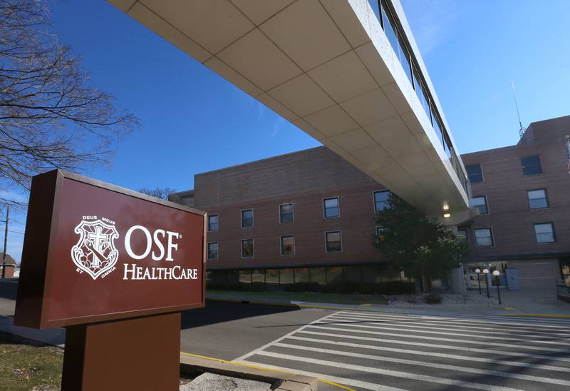 A new OSF Healthcare sign is erected underneath the walkway at the former IVCH and St. Margaret's Hospital on Tuesday, Feb. 20, 2024 in in Peru.