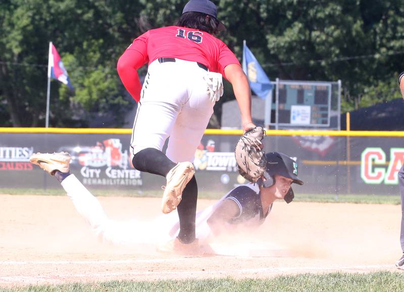 Michigan's William Bush slides under the tag by Burbank's Edgar Villanueva during the Central Regional Baseball Tournament championship on Thursday, July 18, 2024 at J.A. Happ Field in Washington Park in Peru.