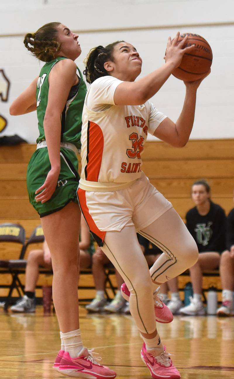 St. Charles East’s Corinne Reed, right, drives to the basket against York’s Stella Kohl during the semifinal of the Montini girls basketball tournament Thursday December 28, 2023 in Lombard.