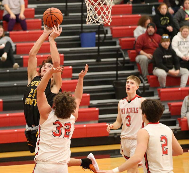 Putnam County's Orlando Harris (21) runs in the lane past Hall defenders Payton Dye (32) Max Bryant (3) and Ashton Pecher (2) to score a basket during the Colmone Classic on Tuesday, Dec. 6, 2022 at Hall Hight School in Spring Valley.