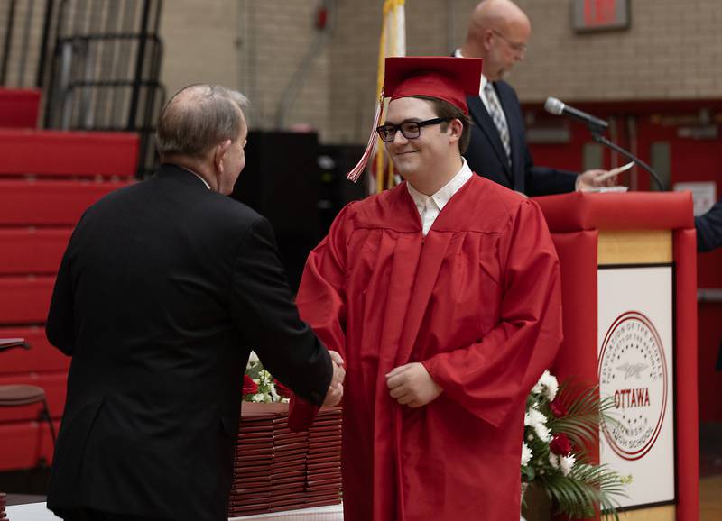 Jack Thiry receives his diploma from Ottawa High School Board President Don Harris on Friday, May 24, 2024, in Kingman Gym.