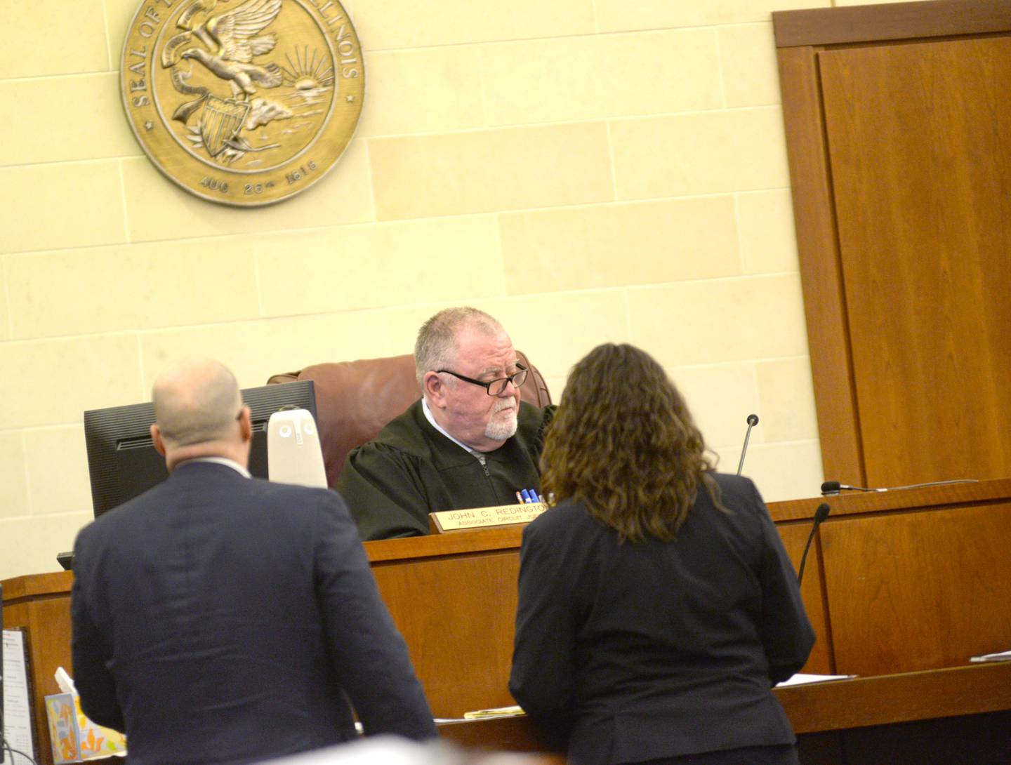 Ogle County Judge John Redington (center) listens to public defenders Kathleen Isley and Michael O'Brien during a hearing for Sarah Safranek on Wednesday, Feb. 14. 2024. Safranek, appeared remotely via a video conference from the Ogle County Correctional Center. She is charged with killing her 7-year-old son, Nathaniel Burton, in 2021. She has pleaded not guilty.