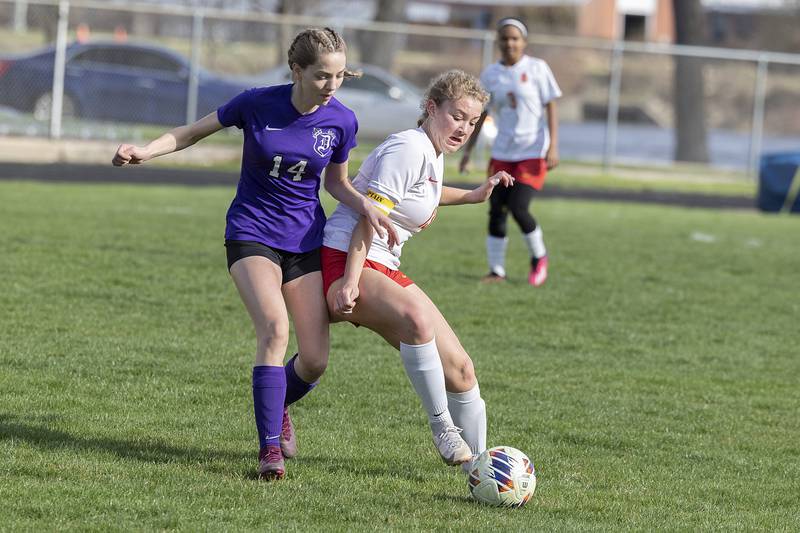 Dixon’s Maggie Van Sickle and Rock Island’s Olivia Samuelson battle for the ball Friday, April 12, 2024 in Dixon.